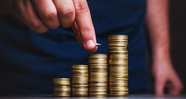 Man's hand put money coins to stack of coins. Money, Financial, Business Growth concept.